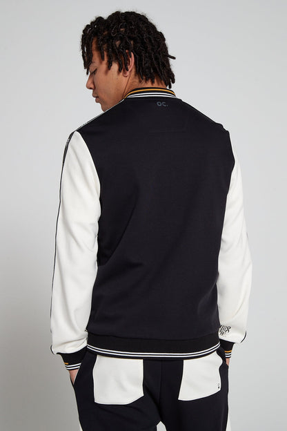 Model showing behind view wearing Original Creator  Zip Jacket in Black and White color with OC branding under the jacket collor and featuring a color combination of white and black