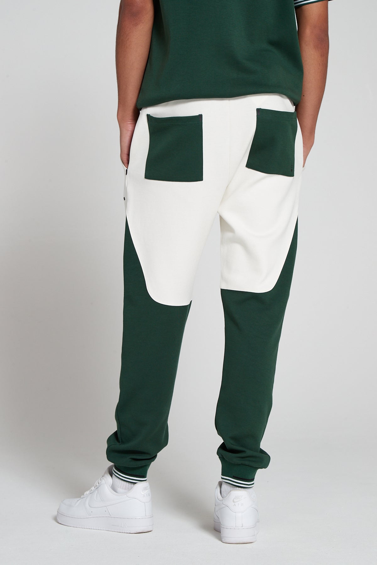 Model showing a behind view wearing Original Creator Track 2.0 Retro Joggers in Varsity Green Color. Features two pockets at the back and white lining on ankles