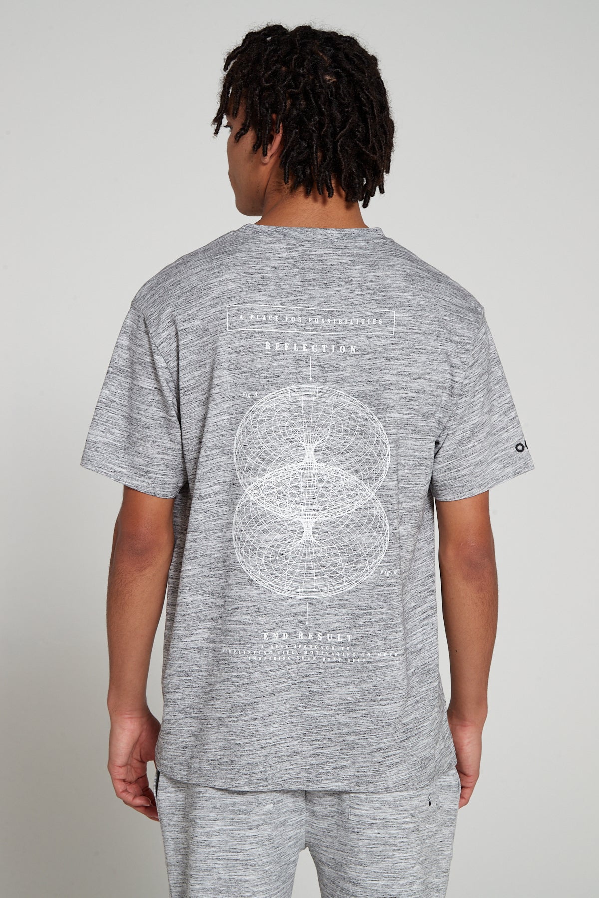 Model showing behind view wearing Original Creator Reflection T-Shirt in Granite Grey color with reflection graphics at the back and features water repellent technology