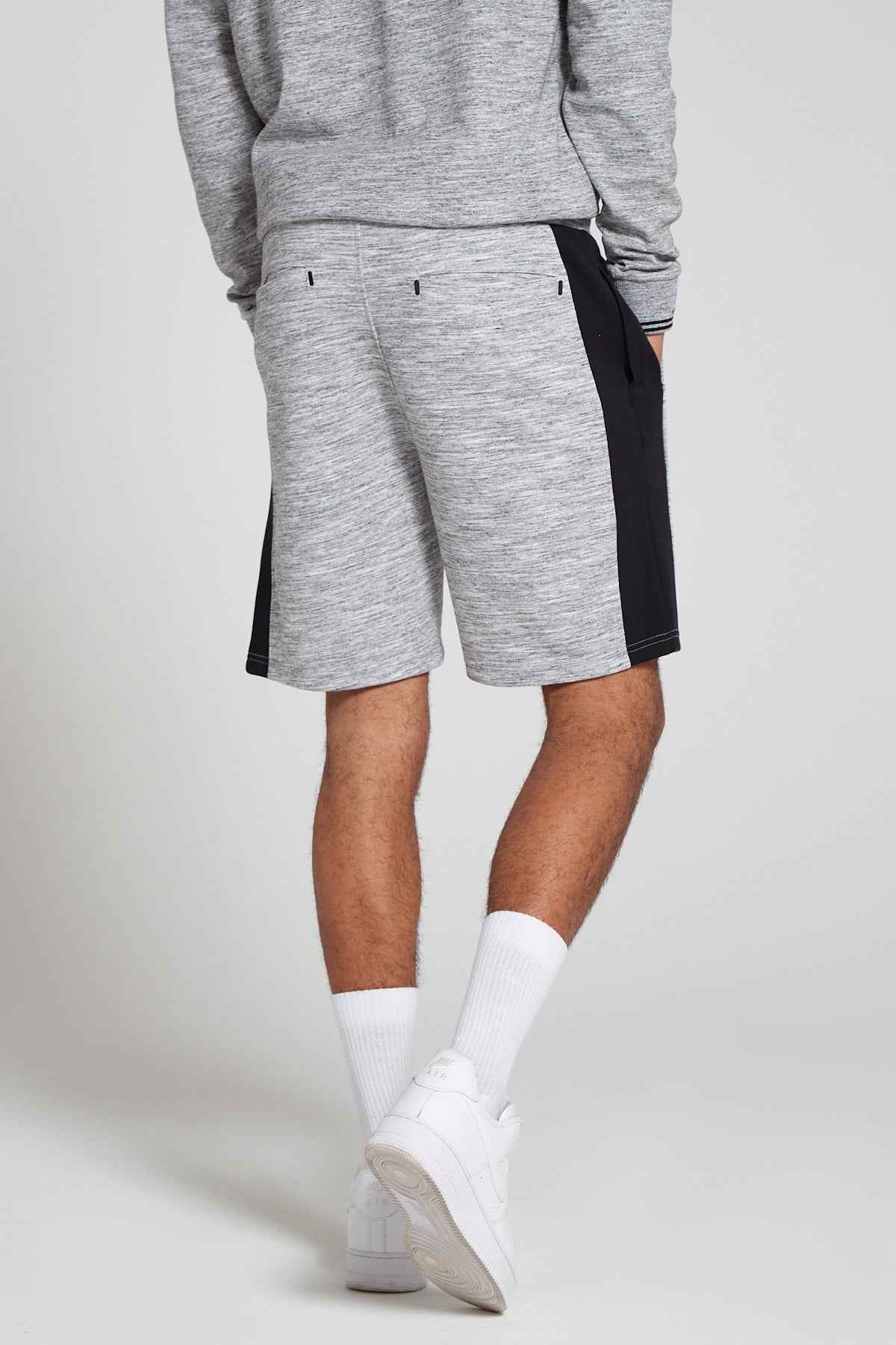 Model showing behind view wearing Original Creator Granite Grey zip pocket shorts with no branding at the back