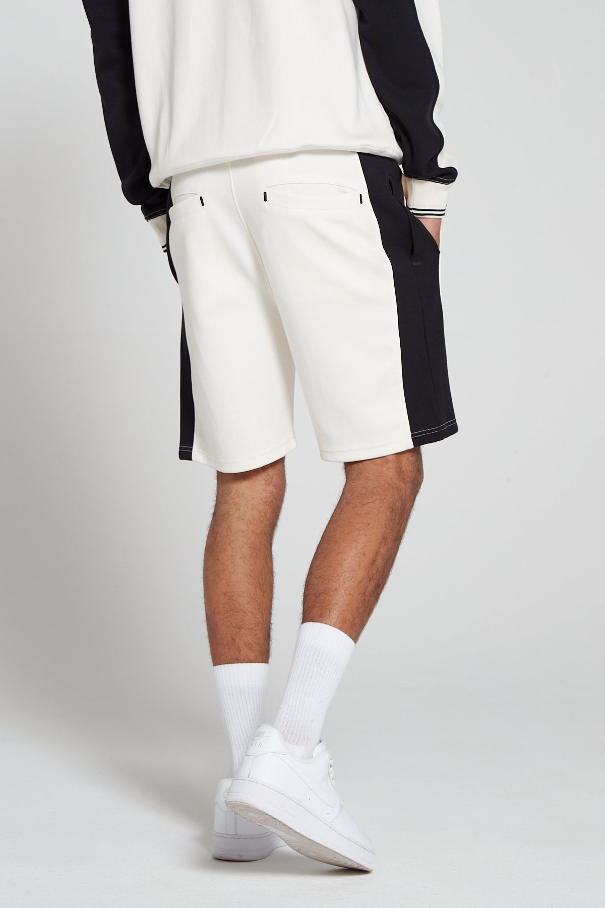 Model showing behind view wearing Original Creator Off White zip pocket shorts with no branding at the back