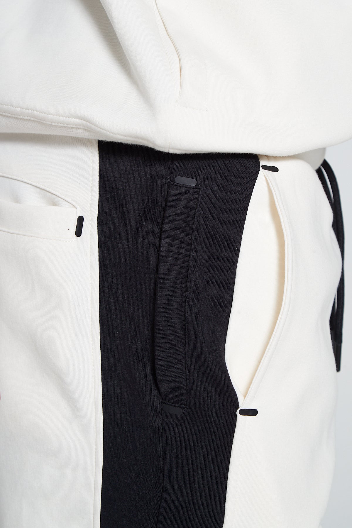 A side angle and close up shot of Original Creator Off White zip pocket shorts with four side pockets. The shorts feature a colour combination of off white and Black and zip pockets