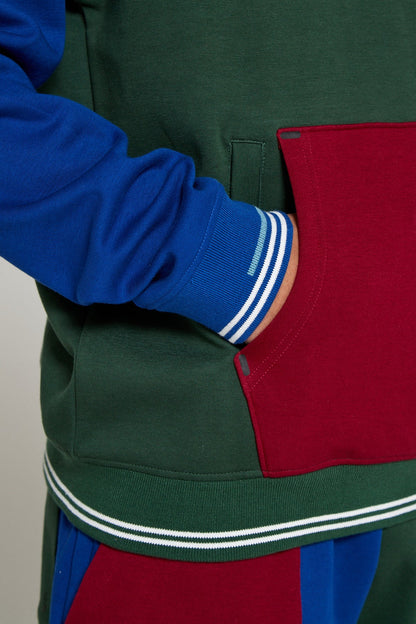 A close up view of model wearing Original Creator oversized Classic Multicolour Hoodie highlighting a kangaroo pocket along with a hidden zipper pocket to protect phone and keys. Most prominent feature is the Signature lining on sleeves to add a classy touch